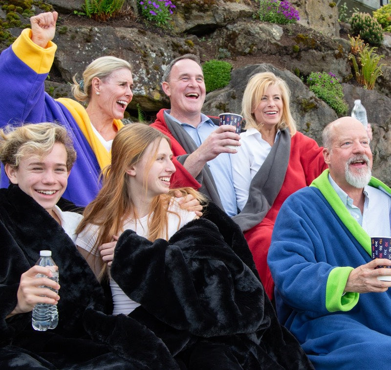 Group watching outdoor sports event wearing two person sweaters